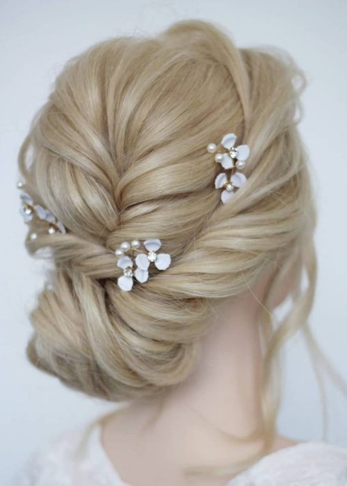 textured wedding hair bun with braid and flower hair pins