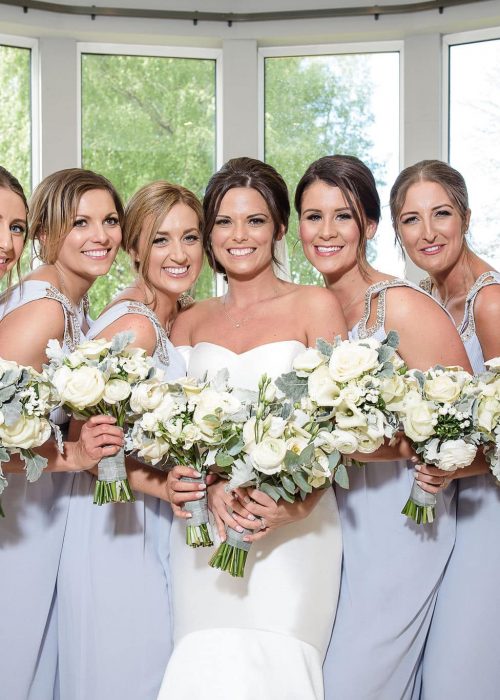 bride and her bridesmaids on the wedding in a conservatory with natural hair and makeup